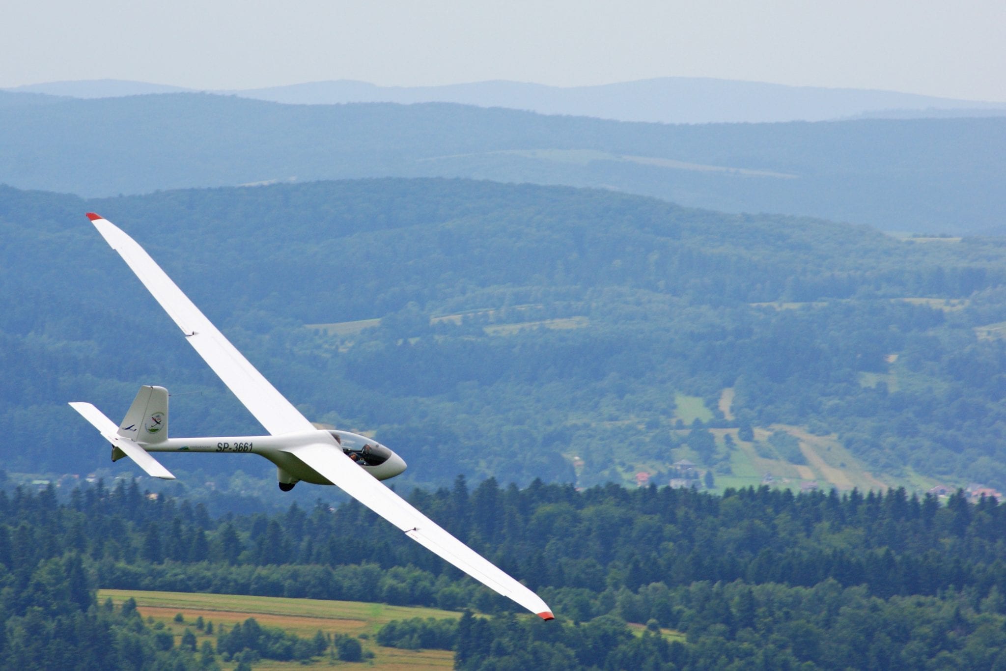 Glider soaring over scenic landscape